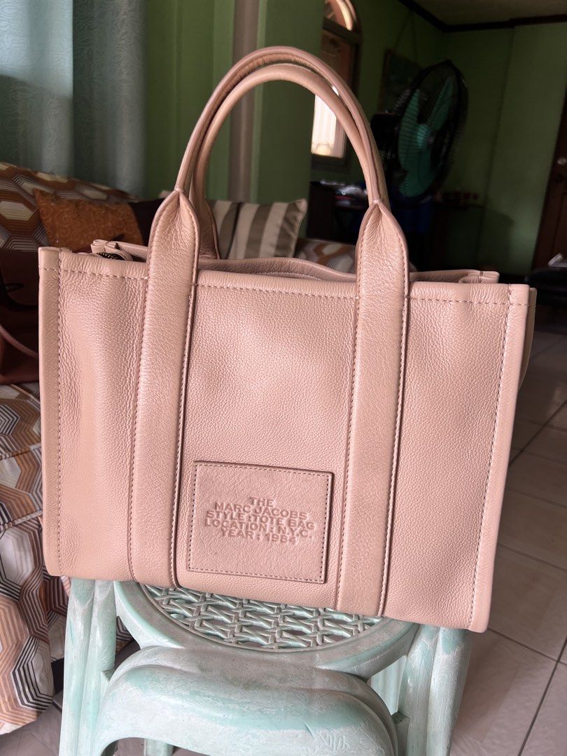 Marc Jacobs The Tote Bag (Category: Luxury Bags & Wallets) located in Quezon City. Submitted by trisha_1998 (Listing ID 1457201816, Image 2). Description: - Authentic Marc Jacobs The Tote Bag - Color: Light pink/nude - Material: Genuine Leather - Signature embossed logo on front - Embossed patch on back - Zipper closure - Spacious interior - Ideal for everyday use - in very good condition.