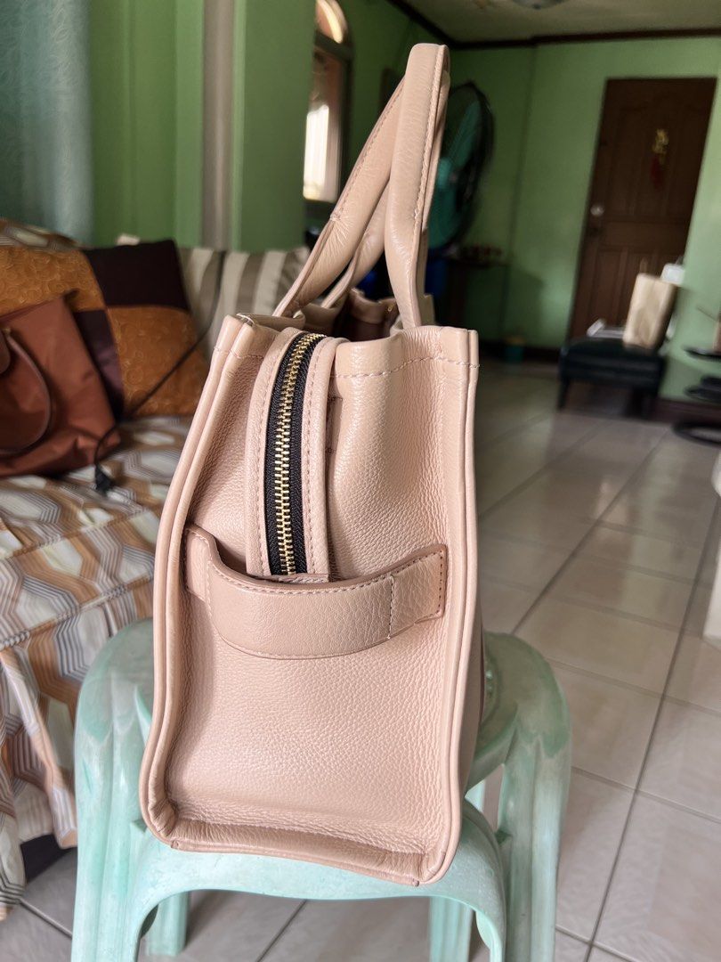 Marc Jacobs The Tote Bag (Category: Luxury Bags & Wallets) located in Quezon City. Submitted by trisha_1998 (Listing ID 1457201816, Image 3). Description: - Authentic Marc Jacobs The Tote Bag - Color: Light pink/nude - Material: Genuine Leather - Signature embossed logo on front - Embossed patch on back - Zipper closure - Spacious interior - Ideal for everyday use - in very good condition.