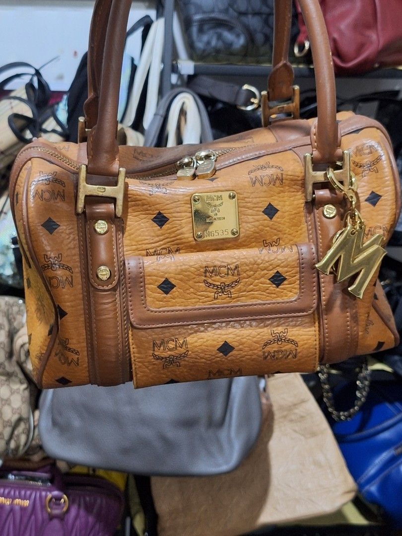 MCM Monogram Canvas Leather Trim Boston Bag (Category: Luxury Bags & Wallets) located in Quezon City. Submitted by cloudymay (Listing ID 1453807264, Image 1). Description: - Classic MCM Boston bag - Iconic monogram print on canvas - Brown leather trim - Gold-tone hardware - Zipper closure - Great everyday bag.
