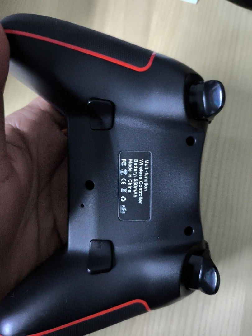 Multi-Function Wireless Controller (Category: Controllers) located in Teluk Intan. Submitted by nhaz95 (Listing ID 1457221408, Image 2). Description: - Sleek black wireless controller with striking red accents. - Full control suite: D-pad, analog sticks, face buttons, shoulder buttons, and triggers. - Long-lasting 550mAh battery for extended gaming sessions. - Versatile multi-platform compatibility. - Ideal for gaming on the go, anywhere, anytime