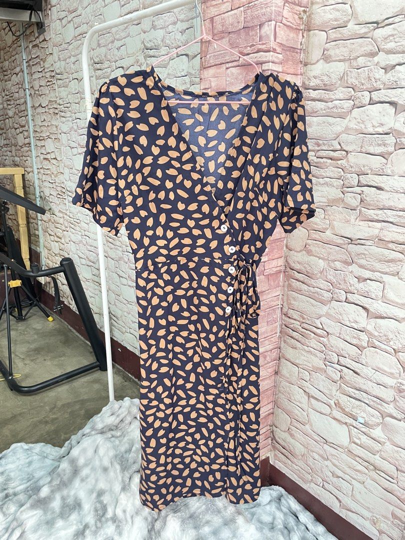 Navy Blue Abstract Print Wrap Midi Dress (Category: Dresses) located in Quezon City. Submitted by queenthingss (Listing ID 1457295256, Image 1). Description: - Navy blue midi dress - Tan abstract print - Wrap style with button details - Adjustable tie at the waist - Short sleeves - Flattering V-neckline - Versatile for dressing up or down.