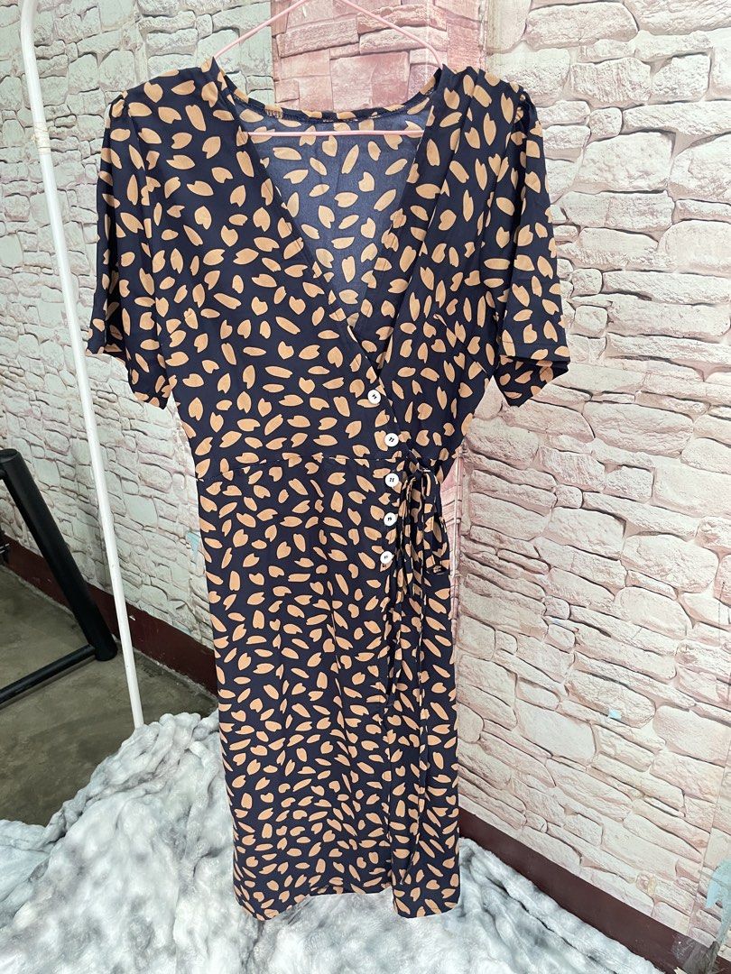 Navy Blue Abstract Print Wrap Midi Dress (Category: Dresses) located in Quezon City. Submitted by queenthingss (Listing ID 1457295256, Image 2). Description: - Navy blue midi dress - Tan abstract print - Wrap style with button details - Adjustable tie at the waist - Short sleeves - Flattering V-neckline - Versatile for dressing up or down.