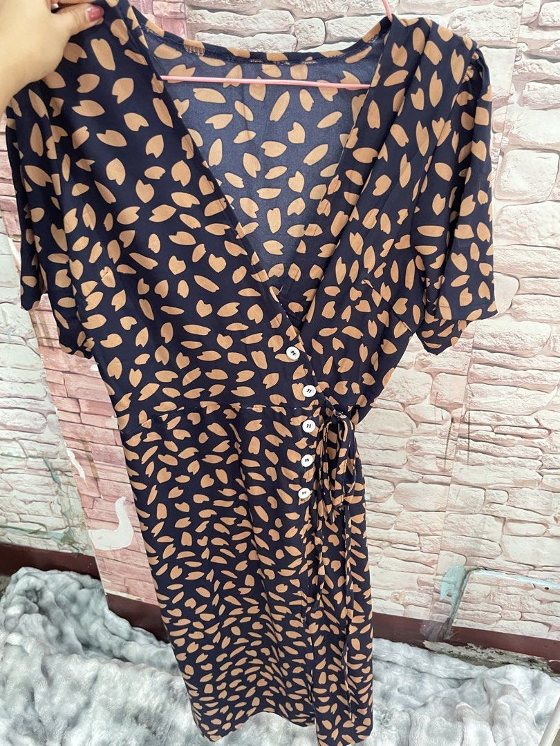 Navy Blue Abstract Print Wrap Midi Dress (Category: Dresses) located in Quezon City. Submitted by queenthingss (Listing ID 1457295256, Image 3). Description: - Navy blue midi dress - Tan abstract print - Wrap style with button details - Adjustable tie at the waist - Short sleeves - Flattering V-neckline - Versatile for dressing up or down.