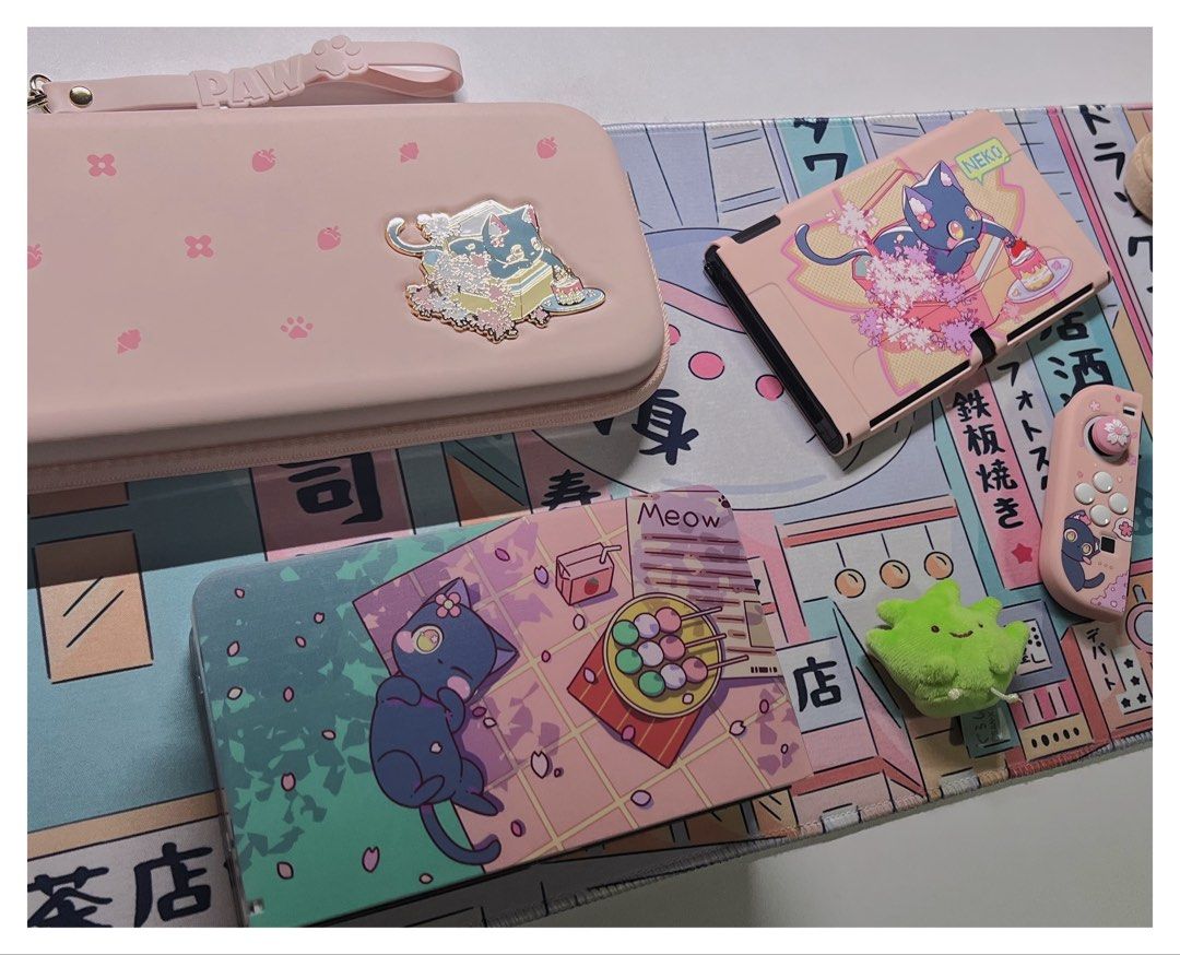 Switch + Games Bundle (OLED) (Category: Nintendo) located in Singapore. Submitted by sobakasu (Listing ID 1457243136, Image 2). Description: - Nintendo Switch Game Bundle: - Persona 5 - Splatoon 2 - Neo: The World Ends With You - The Legend of Zelda: Breath of the Wild - Accessories Included: - Cute pink Neko-themed Switch case - Controller grips - Large desk mat - All games are in their original cases..
