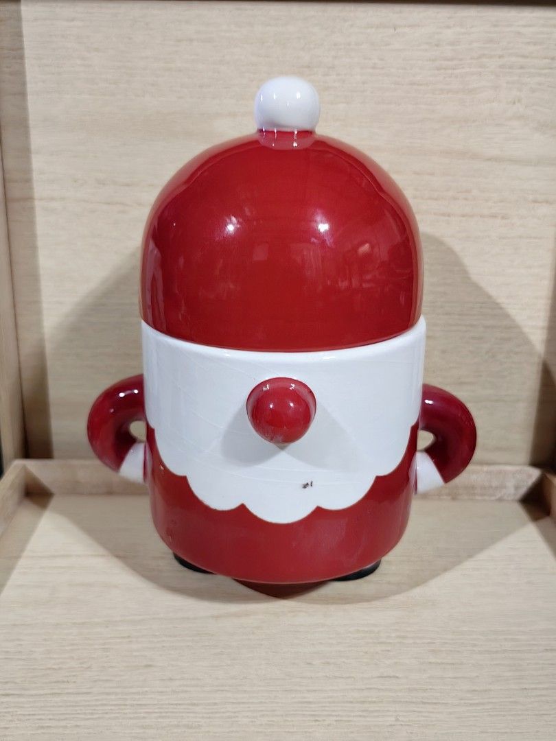Santa ceramic jar with lid (Category: Other Kitchenware & Tableware) located in Calamba. Submitted by princesspauliney. (Listing ID 1457267367, Image 1). Description: whimsical ceramic canister is shaped like a round Santa Claus on skis. It features a glossy red glazed body and cap, accented with a large red nose and a wavy white beard. It serves as a holiday treat or cookie canister that pulls apart at the middle to reveal a food-safe storage co