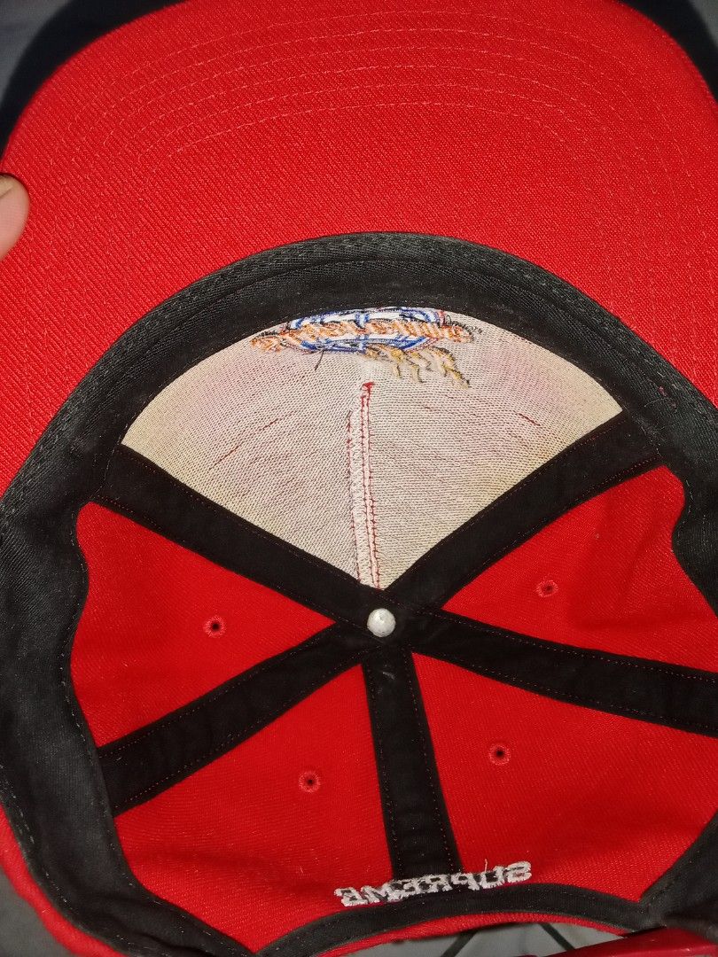 Supreme USA Globe Flames Red Snapback Hat (Category: Caps & Hats) located in Iloilo. Submitted by bakerzero8 (Listing ID 1457316391, Image 3). Description: - Authentic Red Supreme Snapback Cap - Iconic globe with flames logo on the front - 'Supreme' text embroidered on the back - 'Made in USA' tag visible - Adjustable snap closure for a custom fit.