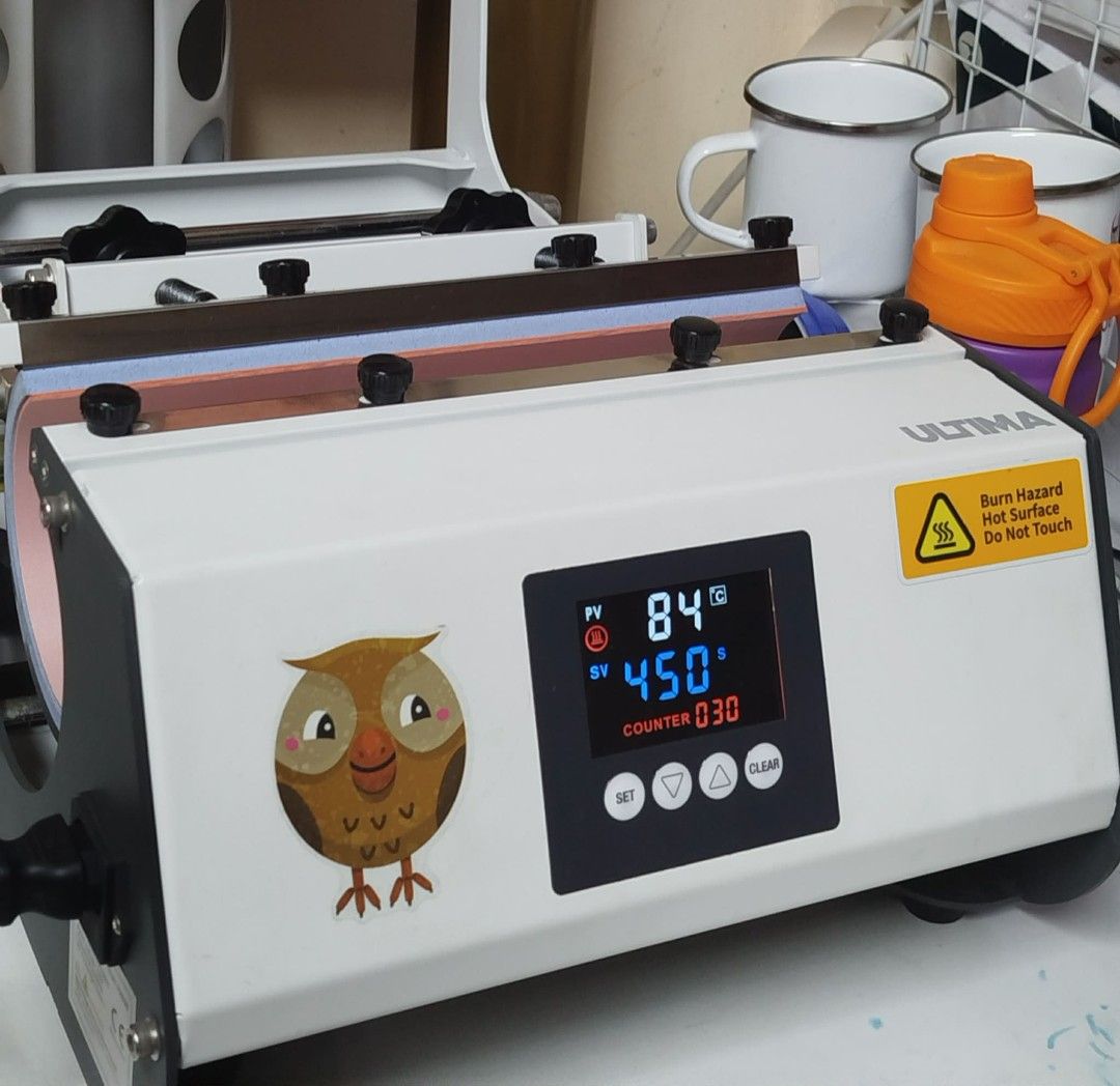Ultima Mug Press Machine (Category: Coffee Machines & Makers) located in Manila. Submitted by jexzel (Listing ID 1457156397, Image 1). Description: - Ultima Heat Press Machine - Ideal for sublimation and heat transfer projects - Digital display for precise temperature and time control - Counter feature (currently at 030) - Stylish white and black design - Includes important hot surface warning label - Comes with a versatile cylindrical attachment