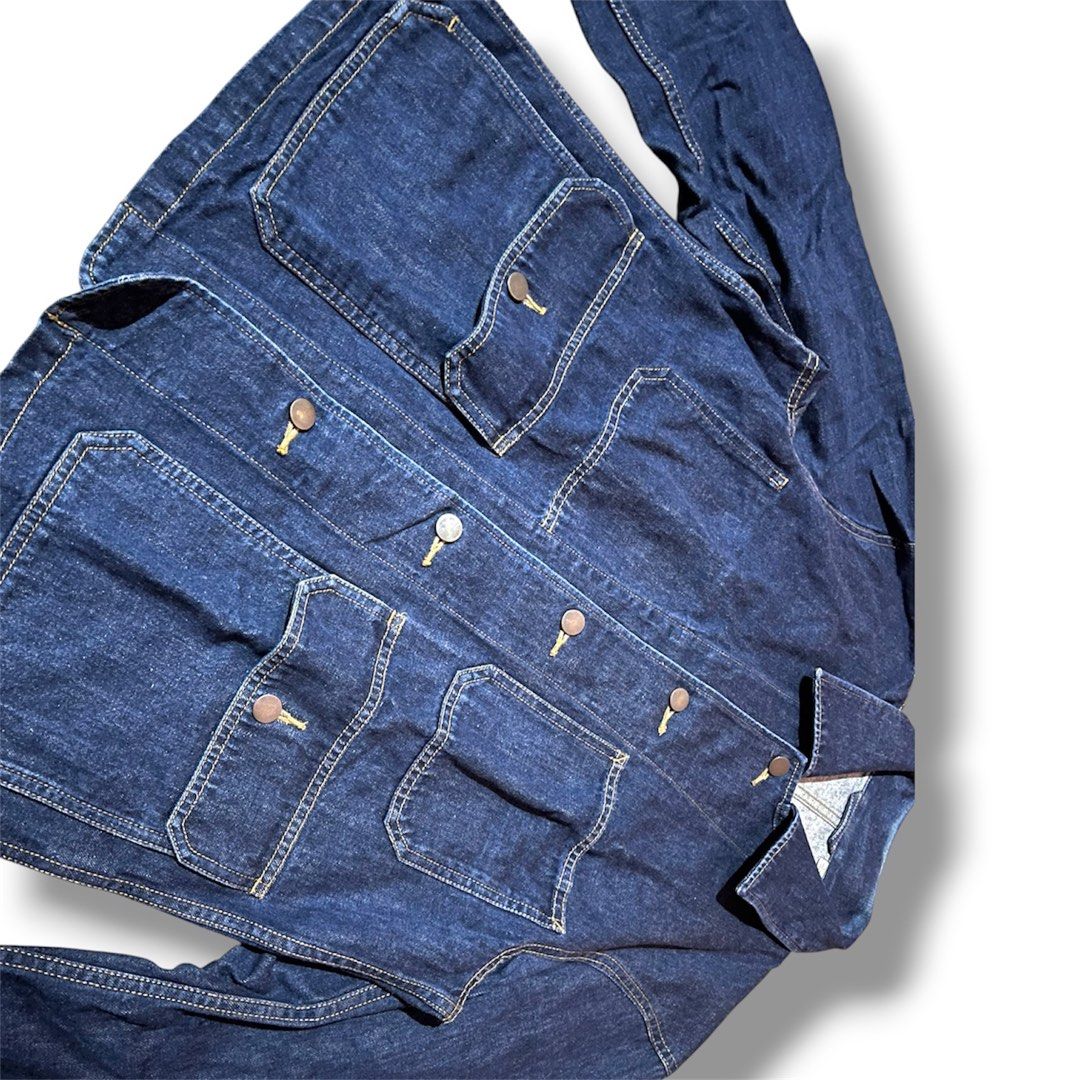 Uniqlo U Denim Work Jacket (Category: Announcements) located in Cebu City. Submitted by lchadpierr03463 (Listing ID 1457284082, Image 2). Description: Pockets: Features four distinctive utility patch pockets. The lower two are larger flap-closure drop pockets, while the top two are open chest compartments. Stitching: Finished with detailed contrast chain-stitching that emphasizes its utilitarian, vintage workwear aesthetic. Cuffs: Incorporates fu