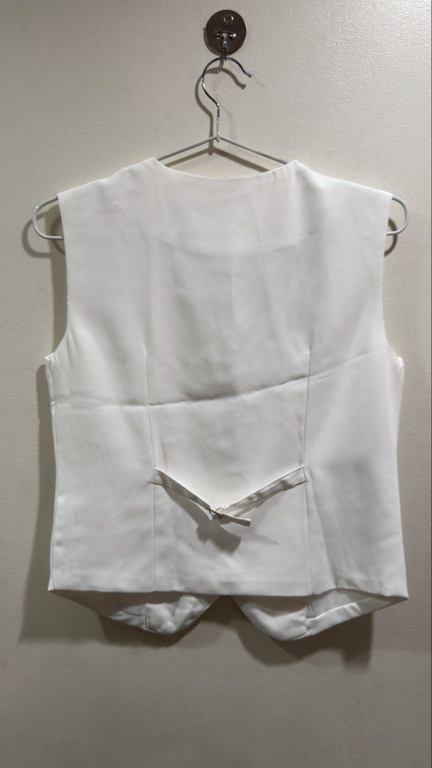 White Formal Vest (Category: Vests) located in Cebu City. Submitted by ngl.prelovedstuff (Listing ID 1457155612, Image 2). Description: - Classic white vest - Button-front closure - Two functional front pockets - Adjustable strap at the back for a customized fit - Smooth, comfortable material - Ideal for formal occasions or as part of a uniform - Excellent layering piece.