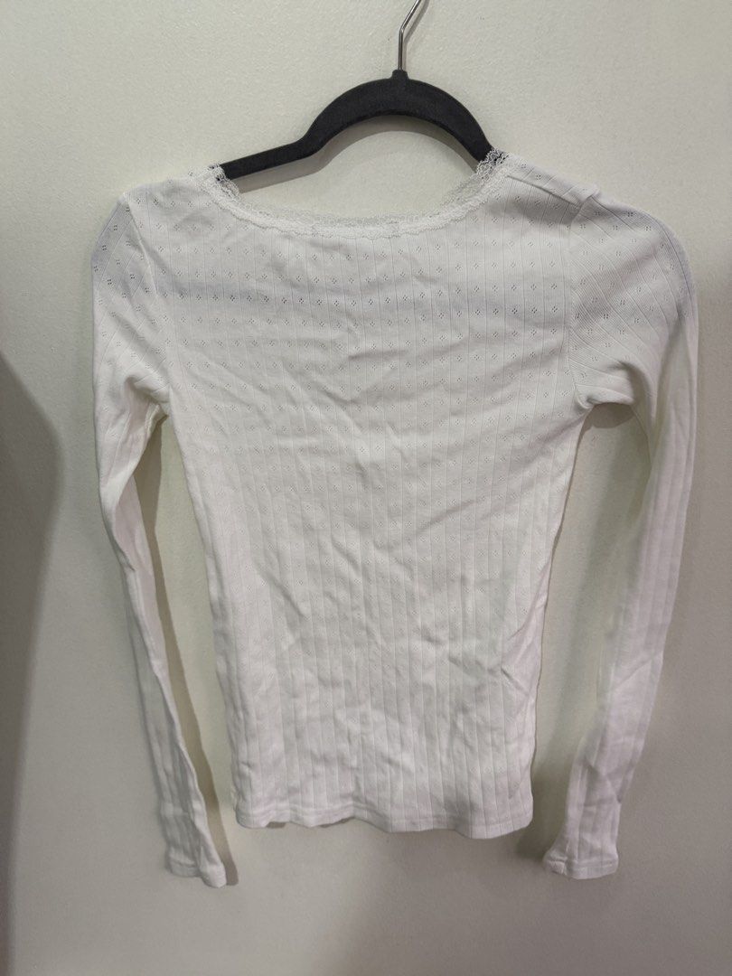 White Pointelle Knit Long Sleeve Top (Category: Longsleeves) located in Muntinlupa City. Submitted by jtarchive (Listing ID 1457256970, Image 3). Description: - Brandy Melville similar long sleeve top - Ribbed material - Delicate lace trim neckline - Small eyelet details on shoulders and sleeves - Cute and dainty design - Ideal for layering or wearing solo.