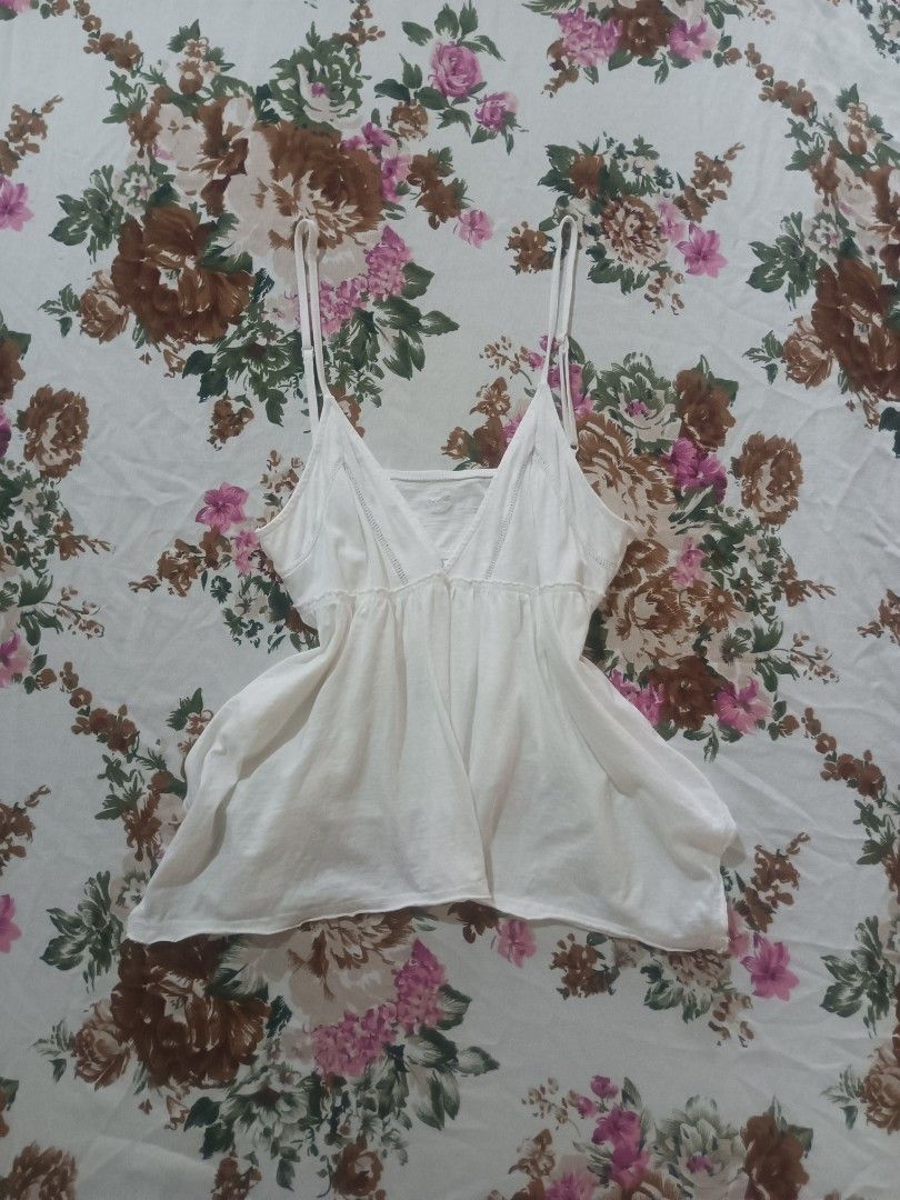 Aerie White Spaghetti Strap Camisole Top (Category: Sleeveless) located in San Pablo. Submitted by halloweenxx (Listing ID 1457437052, Image 1). Description: - Brand: Aerie - Style: White camisole top - Features: Thin spaghetti straps, V-neckline - Detail: Delicate lace trim along neckline and bust - Fabric: Lightweight and flowy - Versatile: Great for layering or wearing on its own - Easy to style with any outfit.