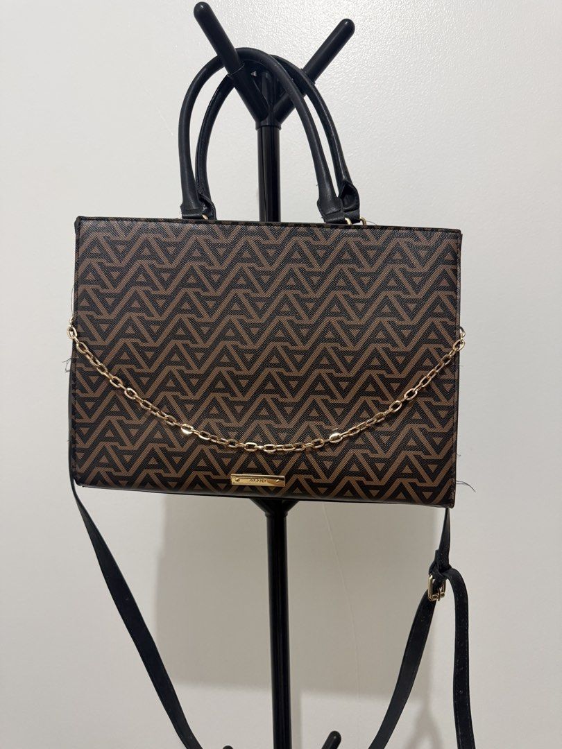 ALDO Monogram Tote Bag with Chain Detail (Category: Luxury Bags & Wallets) located in Manila. Submitted by dnnmrl (Listing ID 1457473879, Image 1). Description: - Stylish ALDO tote bag in brown and black. - Features the signature ALDO monogram print. - Elegant gold chain detail across the front. - Includes comfortable top handles. - Comes with a detachable shoulder strap for versatility. - Shows some signs of wear on handles and strap, adding cha