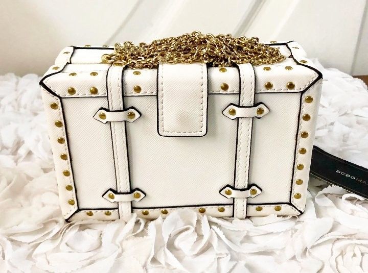 BCBG White structured handbag with gold chain detail (Category: Purses & Pouches) located in Imus. Submitted by sharislane (Listing ID 1457376766, Image 2). Description: - White structured handbag - Gold chain accents and hardware - Tan interior lining - Unique buckle closures - Ideal for night outs or statement outfits - Comes with original tag.