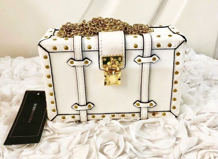 BCBG White structured handbag with gold chain detail (Category: Purses & Pouches) located in Imus. Submitted by sharislane (Listing ID 1457376766, Image 1). Description: - White structured handbag - Gold chain accents and hardware - Tan interior lining - Unique buckle closures - Ideal for night outs or statement outfits - Comes with original tag.