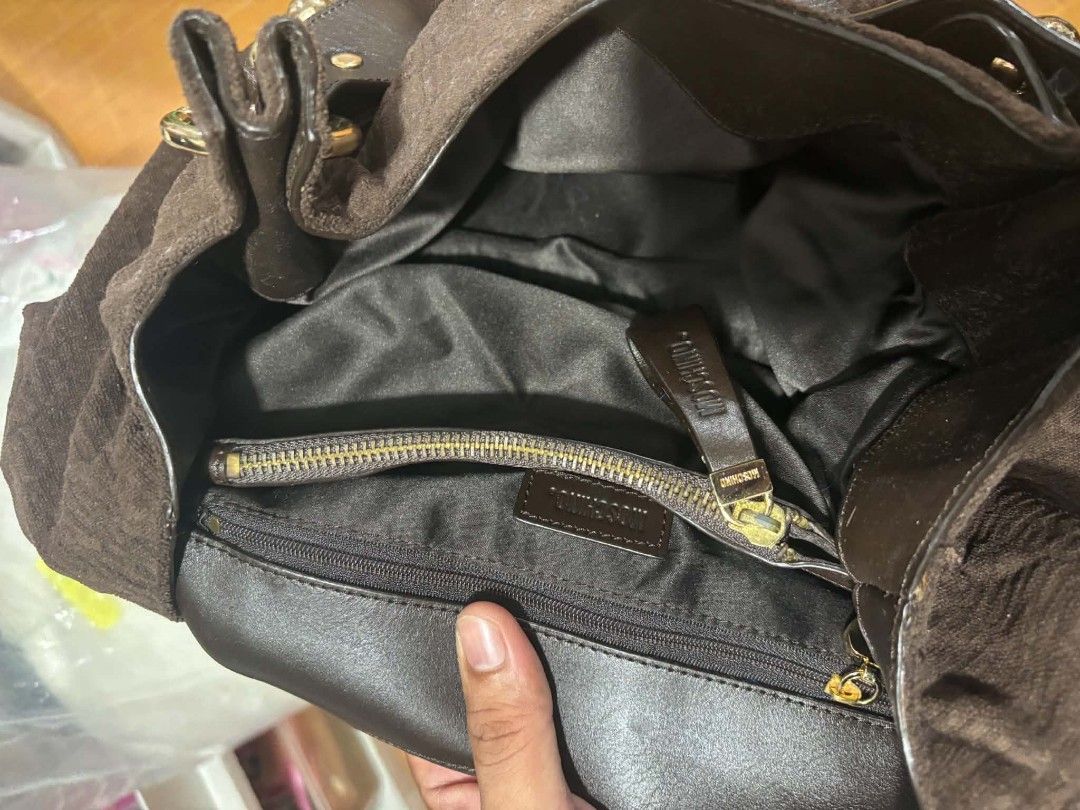 Brown Moschino Monogram Shoulder Bag with Studs (Category: Luxury Bags & Wallets) located in Paranaque City. Submitted by poego (Listing ID 1457449026, Image 3). Description: - Authentic Moschino shoulder bag in classic brown. - Features the signature all-over monogram pattern. - Accented with stylish black leather trim and elegant gold-tone studs. - Offers a spacious interior with a convenient zippered pocket for essentials. - Equipped with doub