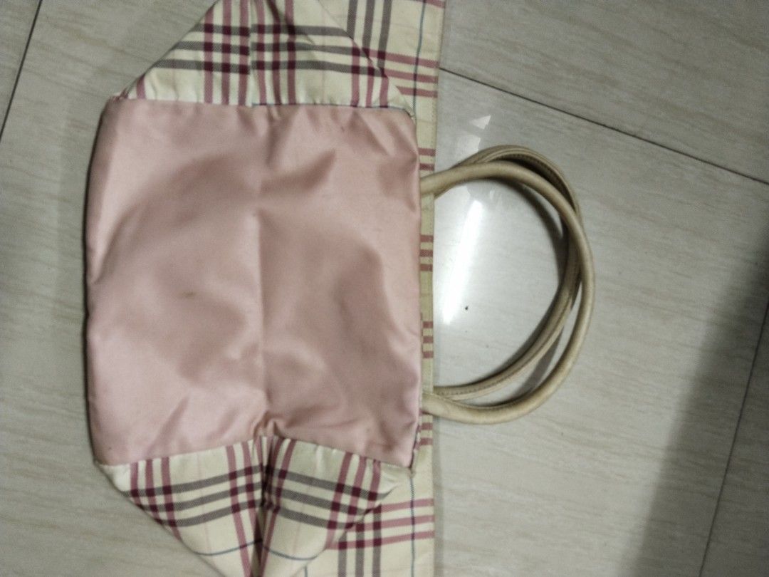 Burberry Blue Label Plaid Tote Bag (Category: Luxury Bags & Wallets) located in Pasay City. Submitted by emelsthrift1997 (Listing ID 1457420843, Image 3). Description: - Authentic Burberry Blue Label tote bag - Iconic Burberry plaid pattern (beige base with maroon and blue lines) - Durable leather handles - Luxurious pink satin interior lining - Shows some signs of wear on handles and exterior fabric - Perfect for stylish everyday use issue: sign