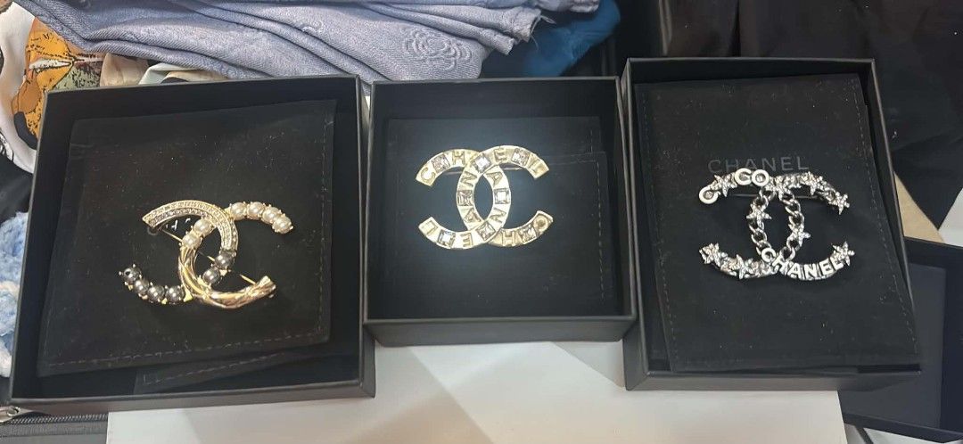 Chanel CC Brooches (Sold separately) (Category: Brooches) located in Quezon City. Submitted by melmgpy (Listing ID 1457452310, Image 1). Description: - Authentic Chanel brooches, perfect statement pieces. - Available styles: - Gold with pearls and crystals. - Gold with crystals spelling 'CHANEL'. - Silver with crystals and chains spelling 'CHANEL'. - All brooches come in their original boxes..