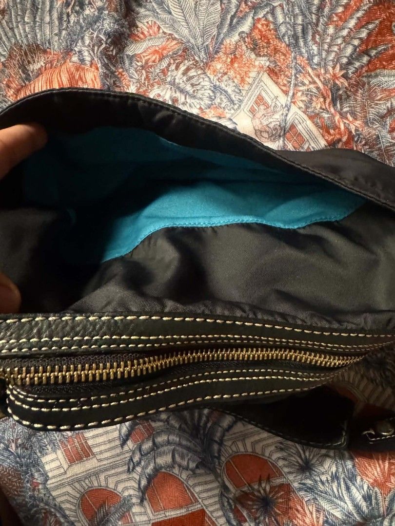 Coach Nylon Hobo Bag (Category: Luxury Bags & Wallets) located in Bacolod City. Submitted by asheroth77 (Listing ID 1457462081, Image 3). Description: - Authentic Coach hobo bag - Durable nylon exterior with leather trim and strap - Elegant gold hardware details - Striking bright teal interior lining - Secure zipper closure - Interior pocket for essentials - Serial number visible on leather tag inside.