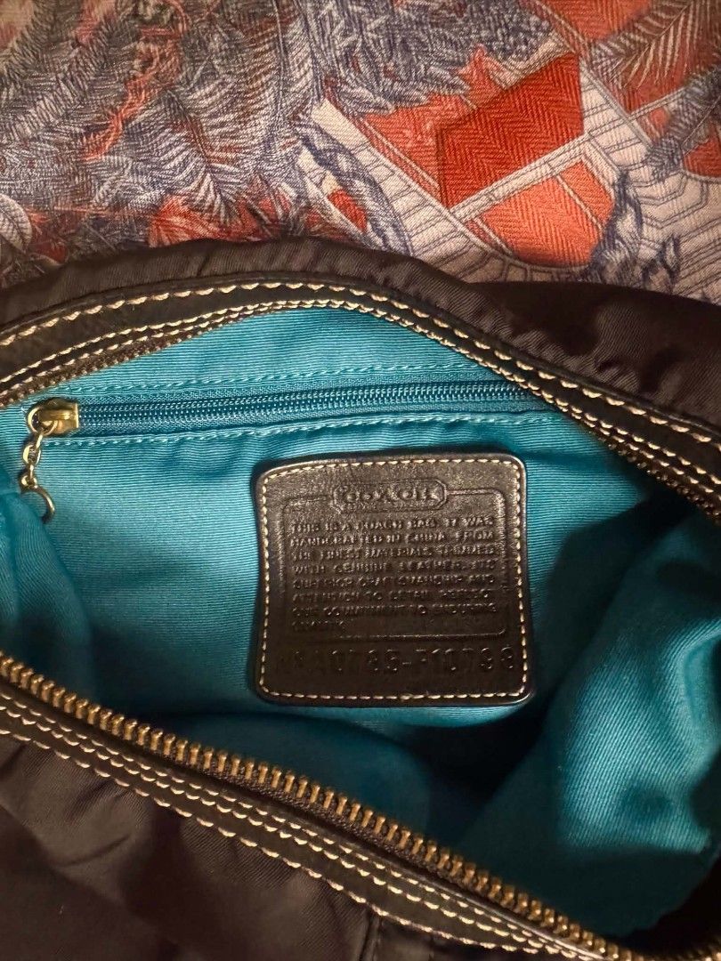 Coach Nylon Hobo Bag (Category: Luxury Bags & Wallets) located in Bacolod City. Submitted by asheroth77 (Listing ID 1457462081, Image 2). Description: - Authentic Coach hobo bag - Durable nylon exterior with leather trim and strap - Elegant gold hardware details - Striking bright teal interior lining - Secure zipper closure - Interior pocket for essentials - Serial number visible on leather tag inside.