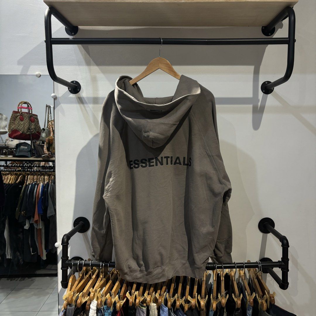 Essentials Zip up Jacket (Category: Coats, Jackets and Outerwear) located in Bambang. Submitted by heats777 (Listing ID 1457442089, Image 3). Description: - Brand: Essentials - Type: Zip-up Jacket - Size: XL (US 44 / UK 44 / EU 54) - Color: Taupe - Features: Soft material, full zip closure, hood, front pockets, 'Essentials' logo on back and sleeve. - Condition: Great.