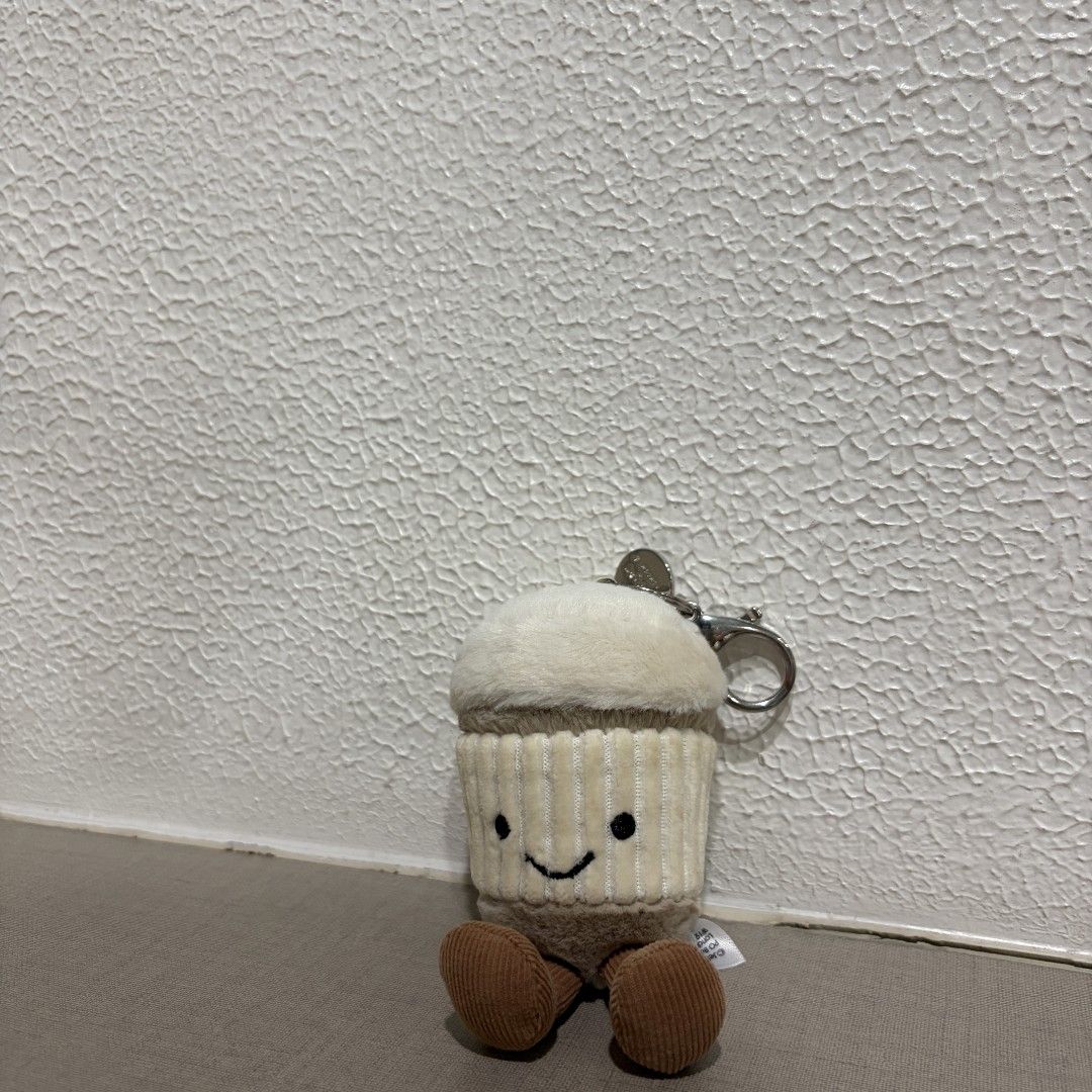 Jellycat Coffee Plush Keychain (Category: Plushies & Soft Toys) located in Manila. Submitted by tidyspace.ph (Listing ID 1457370169, Image 1). Description: - Adorable cupcake plush toy with a keychain attachment. - Made from soft and cuddly material. - Features a cute smiling face and brown feet. - Small and portable, perfect for decorating bags or keys. - An ideal accessory for lovers of cute items..
