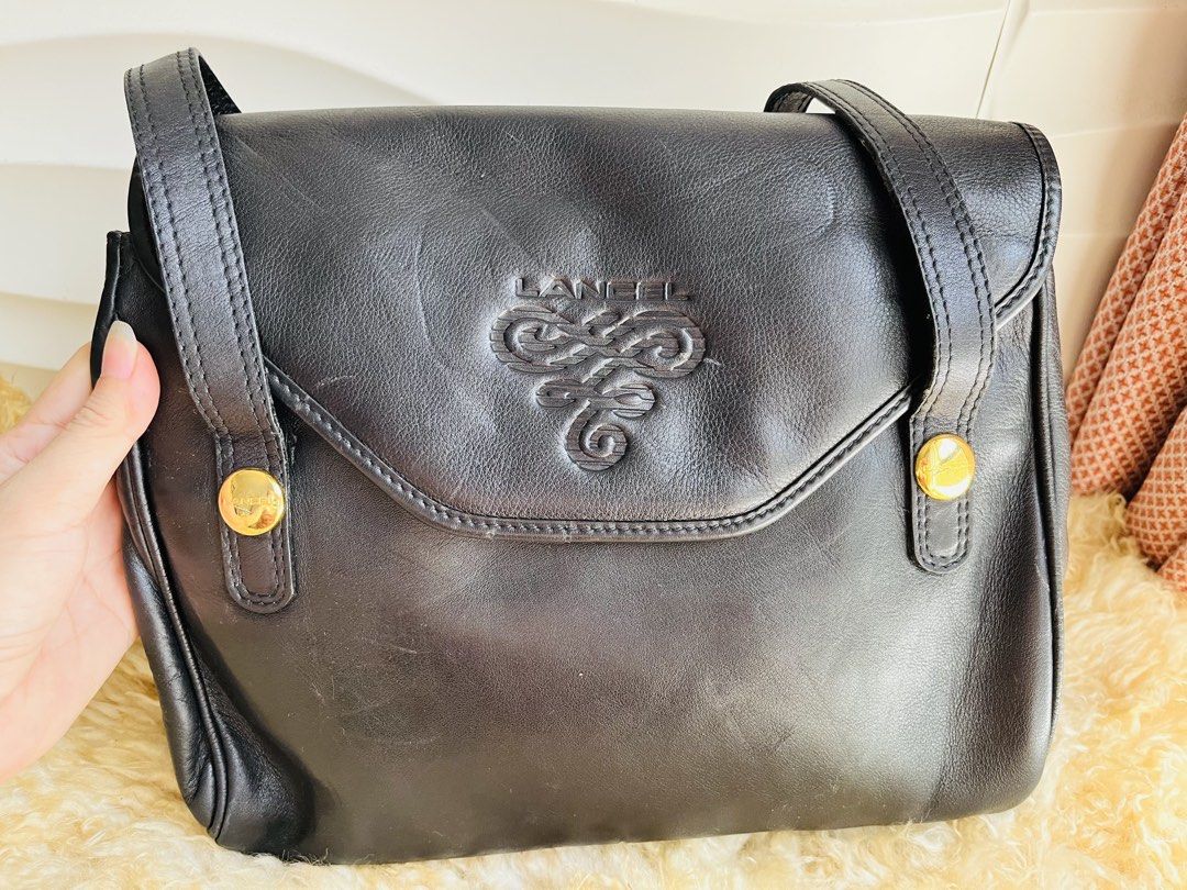 Lancel Long Handle Shoulder Bag (Category: Luxury Bags & Wallets) located in Davao. Submitted by goodthingsph_ (Listing ID 1457343301, Image 3). Description: - Classic black leather shoulder bag by Lancel - Features signature Lancel logo embossed on front flap - Elegant gold-tone hardware details - Adjustable shoulder strap for customized comfort - Timeless and versatile piece for daily use or special occasions.