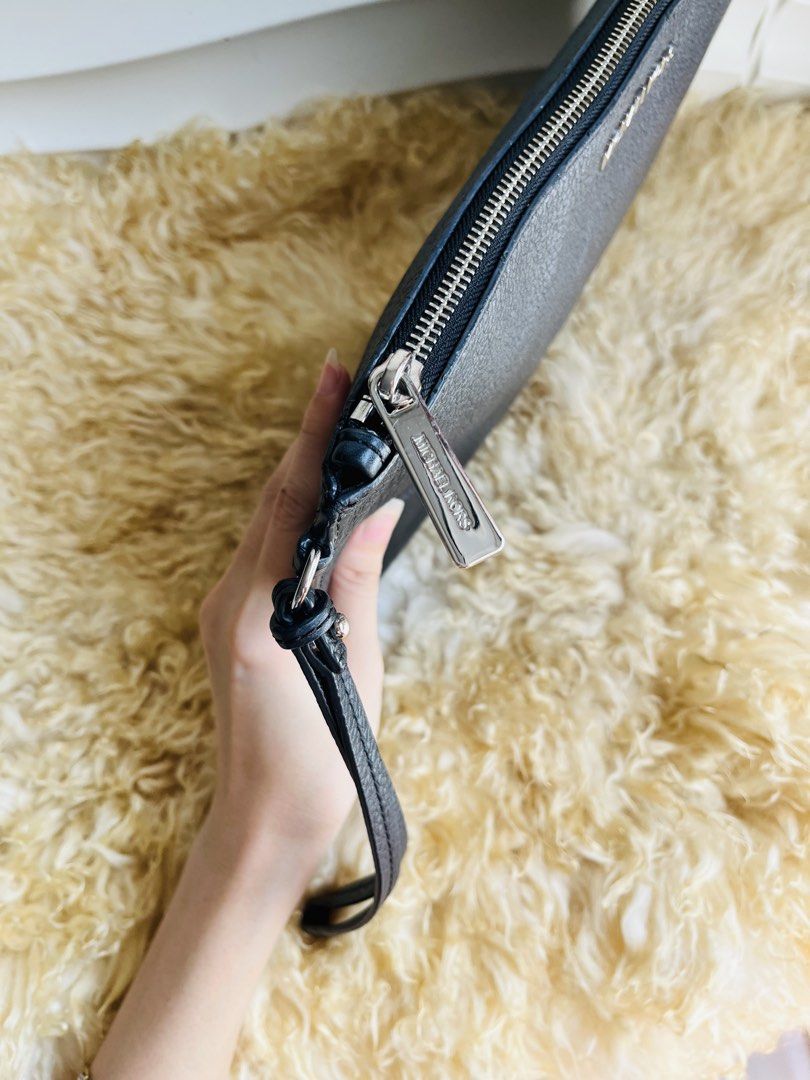 Michael Kors Black Leather Wristlet Clutch (Category: Clutches) located in Davao. Submitted by goodthingsph_ (Listing ID 1457342614, Image 3). Description: - Genuine black pebbled leather Michael Kors clutch 14x9” - Detachable wrist strap for versatility - Secure zip-around closure - Interior zip pocket and card slots for organization - Elegant silver-tone hardware - Ideal size for carrying your daily essentials.