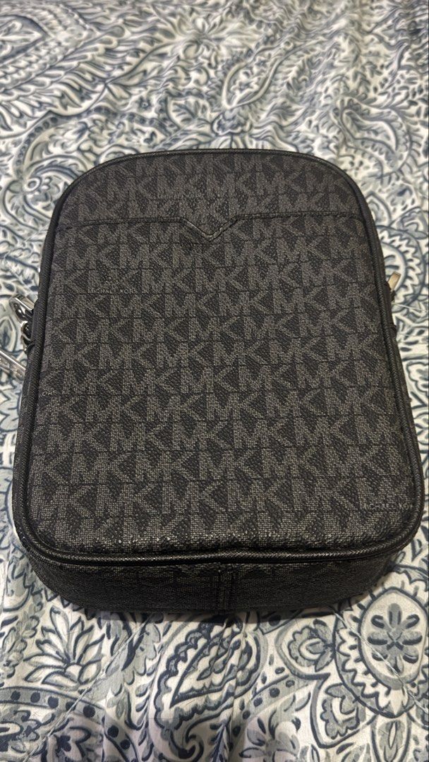 Michael Kors Black Monogram Crossbody Bag (Category: Luxury Bags & Wallets) located in Taguig. Submitted by flostrong (Listing ID 1457440222, Image 2). Description: - Authentic Michael Kors crossbody bag in black. - Features the signature all-over MK monogram print. - Secure zipper closure for the main compartment and a front pocket. - Elegant silver-tone hardware. - Interior includes a convenient small slip pocket. - Ideal for everyday use and c