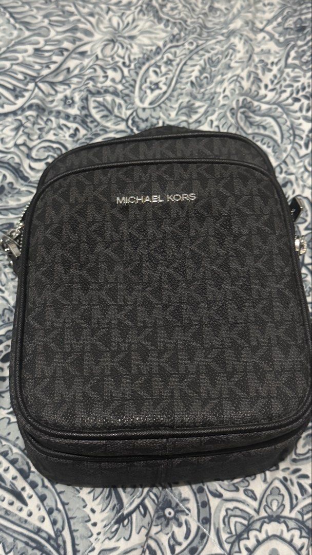 Michael Kors Black Monogram Crossbody Bag (Category: Luxury Bags & Wallets) located in Taguig. Submitted by flostrong (Listing ID 1457440222, Image 1). Description: - Authentic Michael Kors crossbody bag in black. - Features the signature all-over MK monogram print. - Secure zipper closure for the main compartment and a front pocket. - Elegant silver-tone hardware. - Interior includes a convenient small slip pocket. - Ideal for everyday use and c
