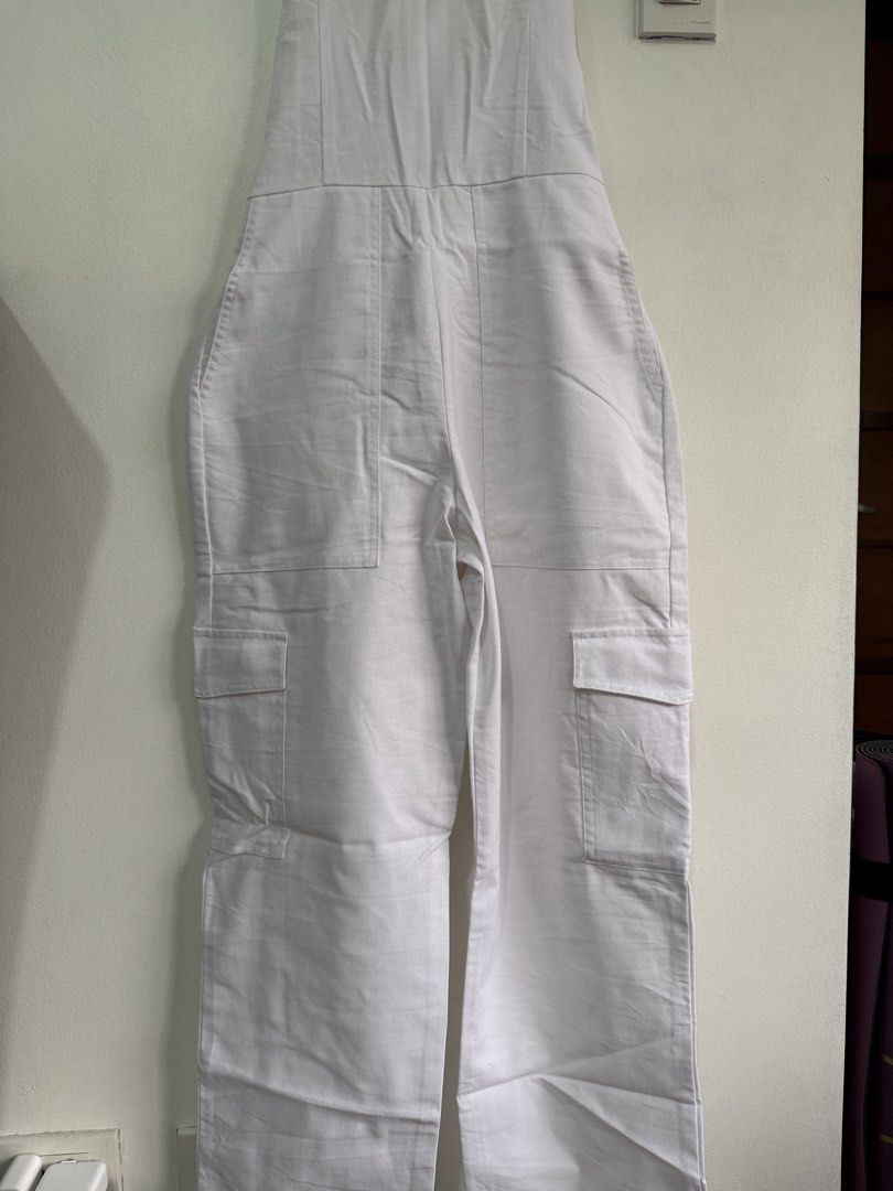 Miu The Label White Halter Neck Cargo Jumpsuit (Category: Jumpsuits) located in Muntinlupa City. Submitted by jtarchive (Listing ID 1457443729, Image 2). Description: - only worn once White halter neck jumpsuit - Back zipper closure - Adjustable neck straps - Multiple cargo pockets on legs - Comfortable and stylish for any occasion - Versatile for casual outings or evening events.
