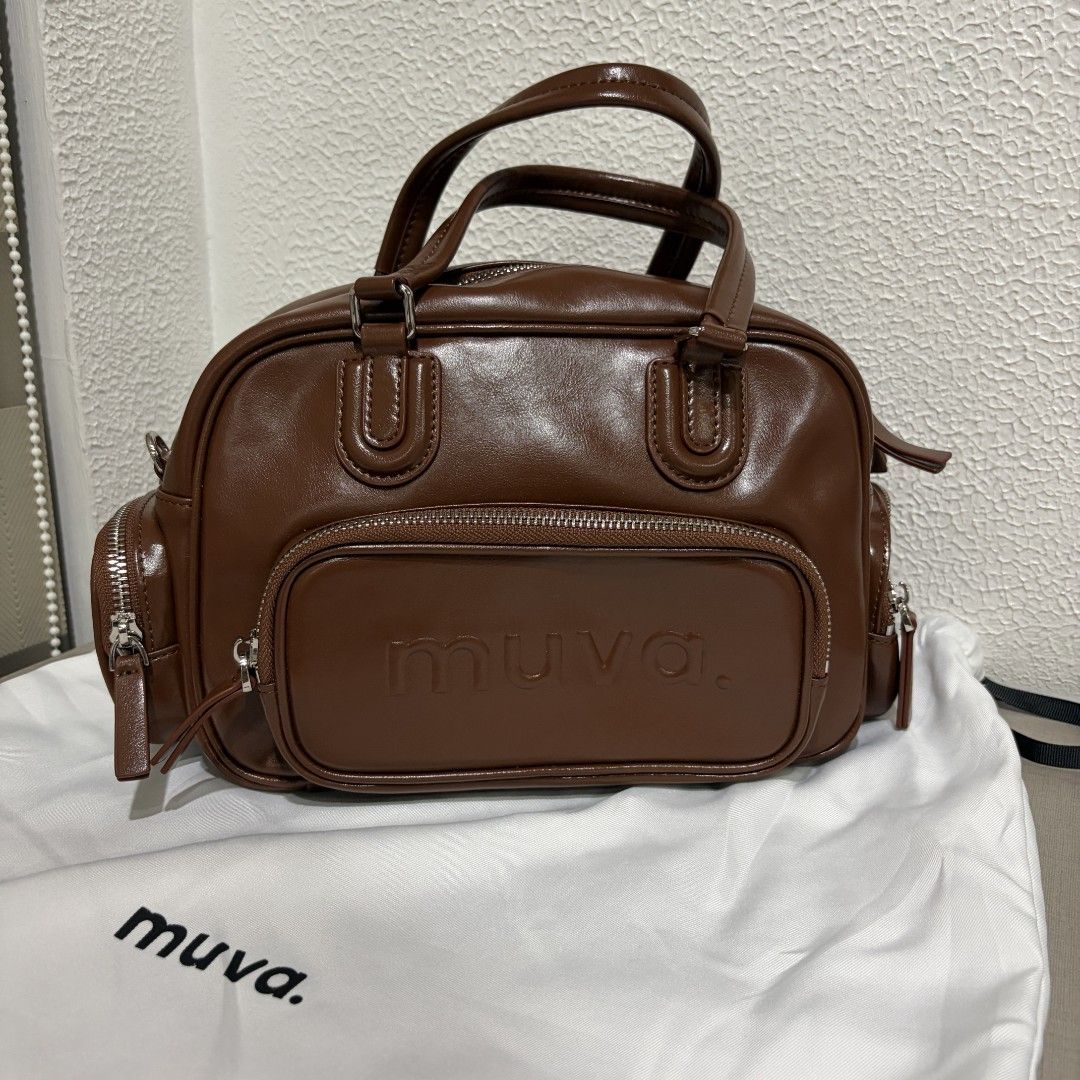 MUVA Three-way Bowler Bag (Category: Luxury Bags & Wallets) located in Manila. Submitted by tidyspace.ph (Listing ID 1457393816, Image 1). Description: - Genuine MUVA brown leather handbag - Main zip compartment for secure storage - Two additional side zip pockets for easy access - Features embossed MUVA logo on the front - Comes with a protective dust bag - Ideal for everyday use and versatility.