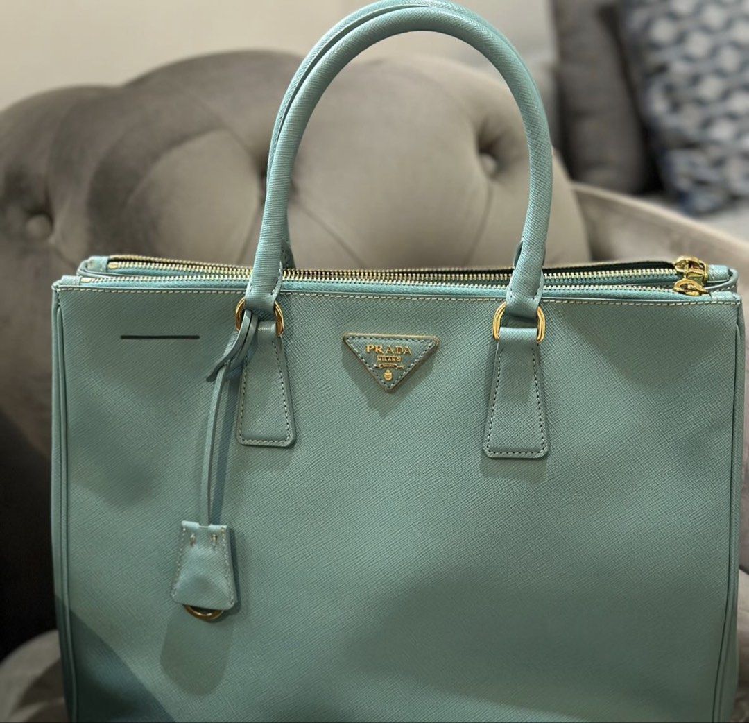 Prada Safiano Lux Double Zip (Category: Luxury Bags & Wallets) located in Muntinlupa City. Submitted by onemanila (Listing ID 1457420695, Image 1). Description: A good office bag, it fits a 13 inch laptop. This is the large size (does not come with strap). A good travel bag as well. Can slip your documents in the zippered compartments. And throw your jacket and book maybe in the middle compartment. In Tiffany blue ans gold hardware..