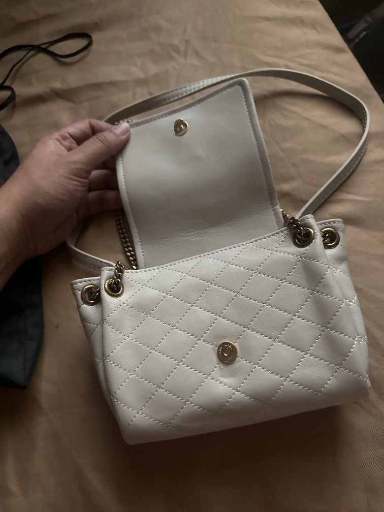 Saint Laurent White Quilted Leather Chain Bag (Category: Luxury Bags & Wallets) located in Pasig City. Submitted by the_bag_agent (Listing ID 1457468165, Image 2). Description: - NGA White quilted leather Saint Laurent bag - Elegant gold chain strap - Secure magnetic snap closure - Interior features black lining with Saint Laurent Paris logo - Comes with dust bag - Versatile for nights out or everyday wear.