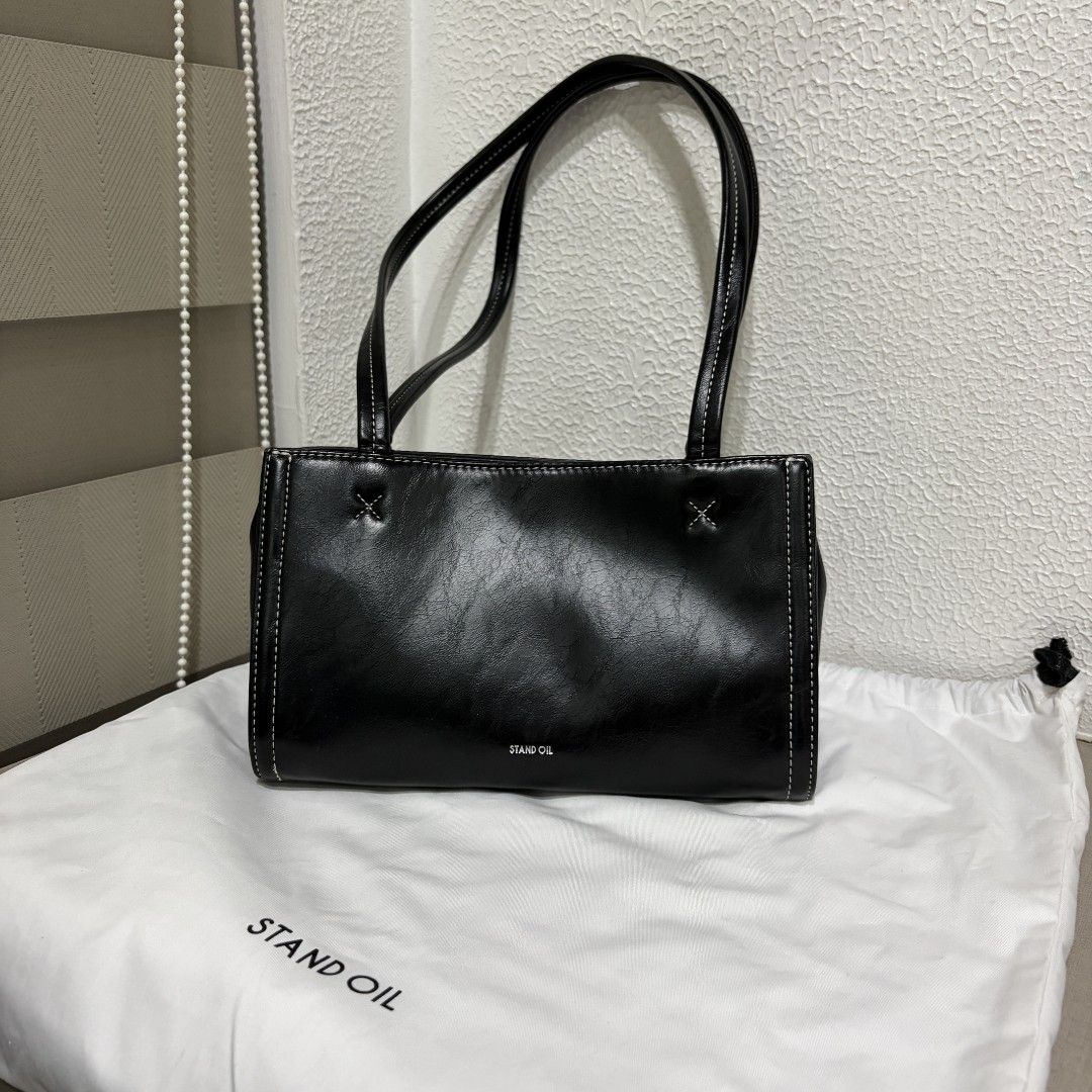 Stand Oil Oblong Bag Tiny (Category: Luxury Bags & Wallets) located in Manila. Submitted by tidyspace.ph (Listing ID 1457394938, Image 1). Description: - Brand: Stand Oil - Color: Black - Design: Simple with white stitching details - Includes: Original dust bag - Ideal for: Everyday use.