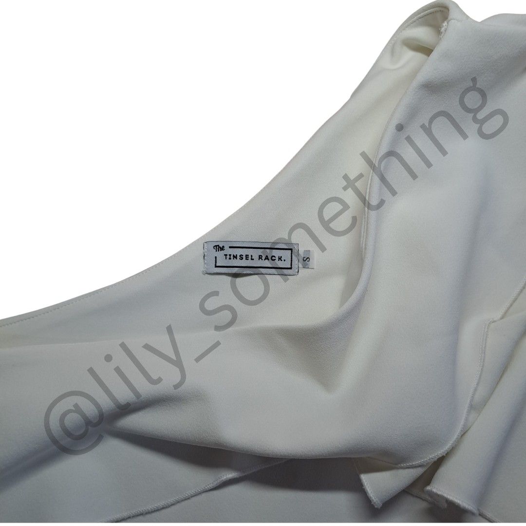 The Tinsel Rack White One Shoulder Ruffle Top Size S (Category: Sleeveless) located in Agdangan. Submitted by lily_something (Listing ID 1457420865, Image 2). Description: - White one-shoulder top - Features a ruffle detail across the front - Brand: The Tinsel Rack - Estimated size: S - Highly versatile: dress up or down - Pairs well with skirts and pants.