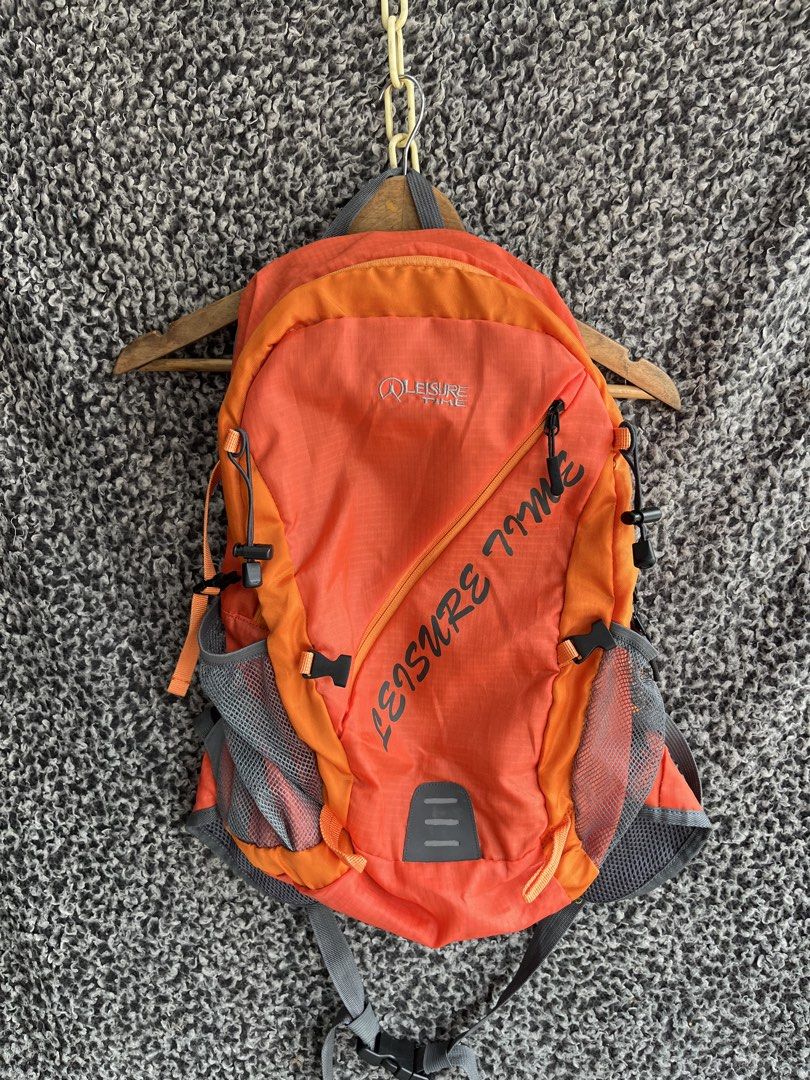 Treksta Leisure Time 28L Hiking Backpack. (Category: Backpacks) located in General Trias. Submitted by zrchustle.604 (Listing ID 1457413812, Image 1). Description: Treksta Leisure Time 28L Hiking Backpack. Key FeaturesBrand: Treksta (Leisure Time series) Capacity: 28 Liters Design: Vibrant orange and grey dual-tone styling with large diagonal "LEISURE TIME" text graphicsBuild: Includes mesh side pockets for water bottles, a bottom reflective acce
