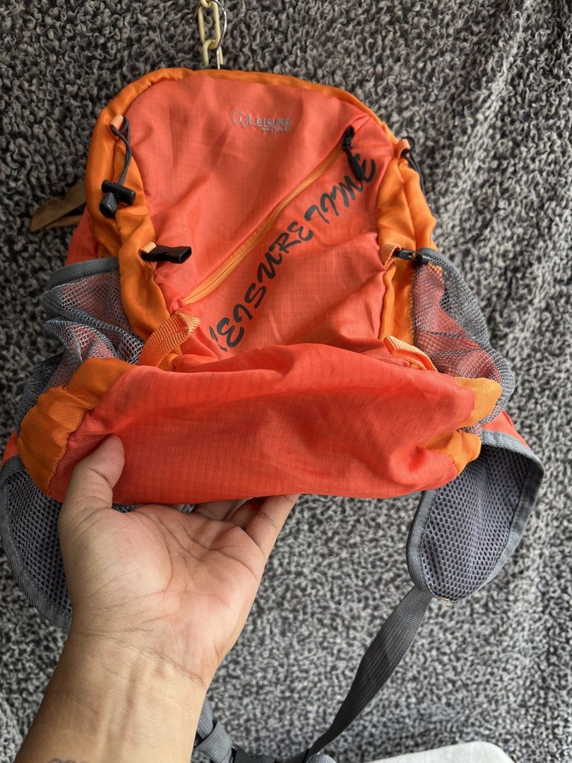 Treksta Leisure Time 28L Hiking Backpack. (Category: Backpacks) located in General Trias. Submitted by zrchustle.604 (Listing ID 1457413812, Image 3). Description: Treksta Leisure Time 28L Hiking Backpack. Key FeaturesBrand: Treksta (Leisure Time series) Capacity: 28 Liters Design: Vibrant orange and grey dual-tone styling with large diagonal "LEISURE TIME" text graphicsBuild: Includes mesh side pockets for water bottles, a bottom reflective acce
