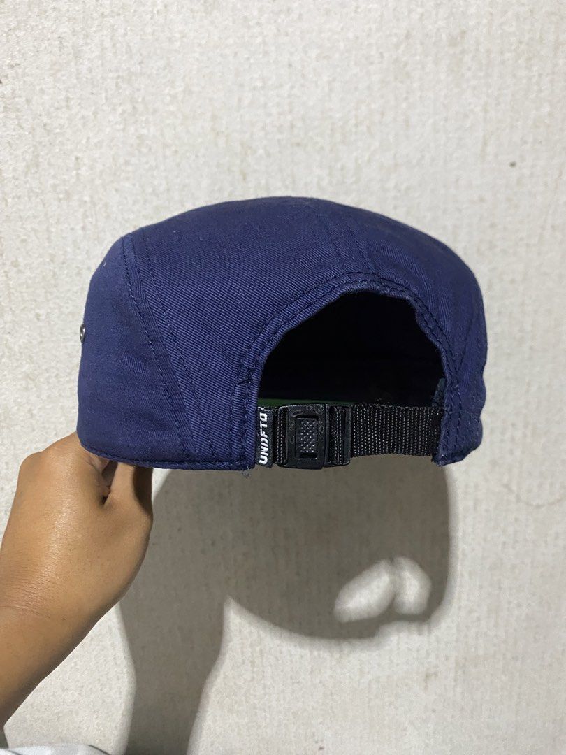 UNDFTD 5 Panel Cap Navy Blue (Category: Caps & Hats) located in Puerto Princesa. Submitted by earlpogitrhift (Listing ID 1457398209, Image 3). Description: - Navy blue UNDFTD 5-panel cap - Features 'UNDFTD P.E. 310' graphic on the front - Adjustable strap at the back for a customized fit - Green underbrim for added style - Made in China - Ideal for everyday wear.