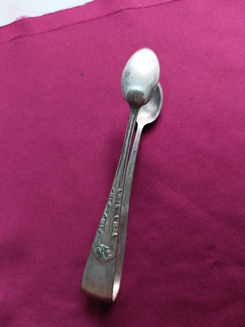 Vintage Silver Sugar Tongs with Spoon Ends (Category: Dinnerware & Cutlery) located in Batangas. Submitted by lavu4555 (Listing ID 1457373593, Image 2). Description: - Antique silver color sugar tongs - Features two small spoon ends for serving - Ornate detailing on the handles - Ideal for sugar cubes or small appetizers - Adds vintage charm to kitchen or tea set.