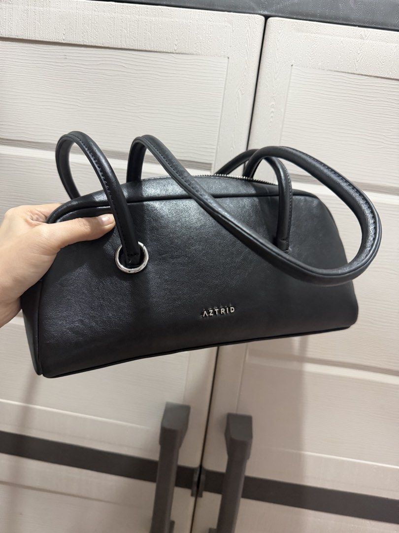 AZTRID Black Leather Handbag (Category: Shoulder Bags) located in Davao. Submitted by fabdeclutter (Listing ID 1457671844, Image 1). Description: - Brand: AZTRID - Material: Black Leather - Closure: Top Zip - Handles: Two rounded top handles - Hardware: Silver detail on the side - Style: Simple and classic - Ideal for: Everyday use.