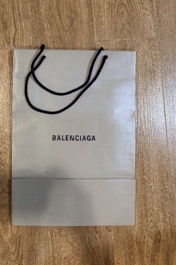 Balenciaga Shopping Bag (Category: Luxury Bags & Wallets) located in Marikina City. Submitted by teacher.maria (Listing ID 1457600751, Image 1). Description: - Authentic Balenciaga paper shopping bag - Color: Light grey - Handles: Black rope - Ideal for carrying purchases or display.