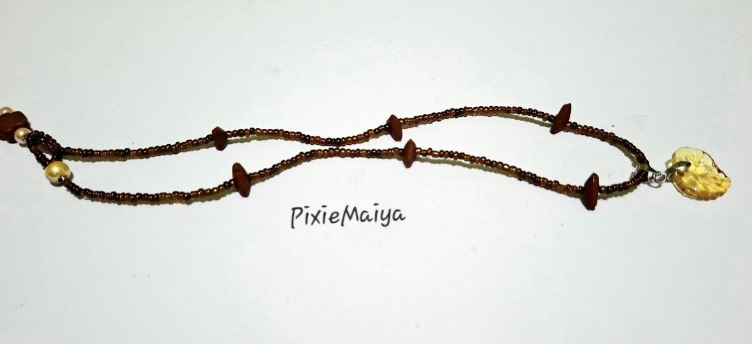Beaded Necklace with Leaf Pendant (Category: Necklaces) located in Valenzuela. Submitted by pixieworks64309 (Listing ID 1457709235, Image 3). Description: - Unique handmade brown beaded necklace - Features wooden accents - Translucent yellow leaf pendant - Includes small cream-colored beads - Adorned with a flower-shaped bead - Adds a natural touch to any outfit.