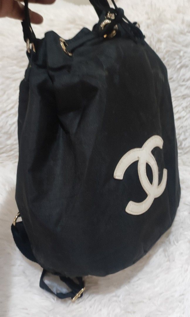 CC VIP Drawstring Bag (Category: Luxury Bags & Wallets) located in Makati City. Submitted by yerbua103 (Listing ID 1457684038, Image 3). Description: This is a black Chanel VIP drawstring bag/mini backpack featuring a prominent CC logo patch. It has a gold-tone hardware and a black nylon drawstring closure. First 2 pics are for reference only. Manage your expectations as you're buying a preloved/ukay bag. .