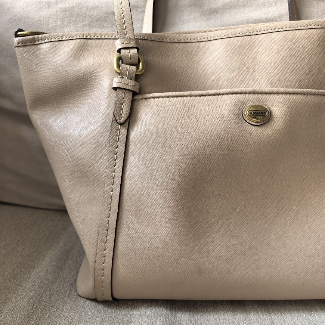 Coach Beige Leather Tote Bag with sling (Category: Luxury Bags & Wallets) located in Dasmarinas. Submitted by mdsmak (Listing ID 1457521468, Image 2). Description: - Authentic Coach tote bag in versatile beige leather. - Classic design with a convenient front and back pockets. - Secure top zip closure for your belongings. - comes with adjustable sling - Interior includes a zip and open pockets for organization. - Elegant gold hardware details add