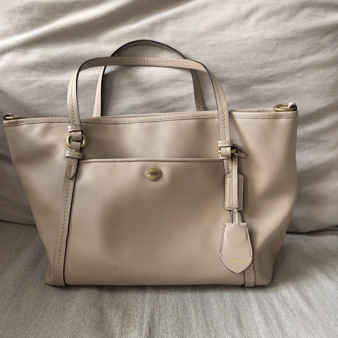 Coach Beige Leather Tote Bag with sling (Category: Luxury Bags & Wallets) located in Dasmarinas. Submitted by mdsmak (Listing ID 1457521468, Image 1). Description: - Authentic Coach tote bag in versatile beige leather. - Classic design with a convenient front and back pockets. - Secure top zip closure for your belongings. - comes with adjustable sling - Interior includes a zip and open pockets for organization. - Elegant gold hardware details add