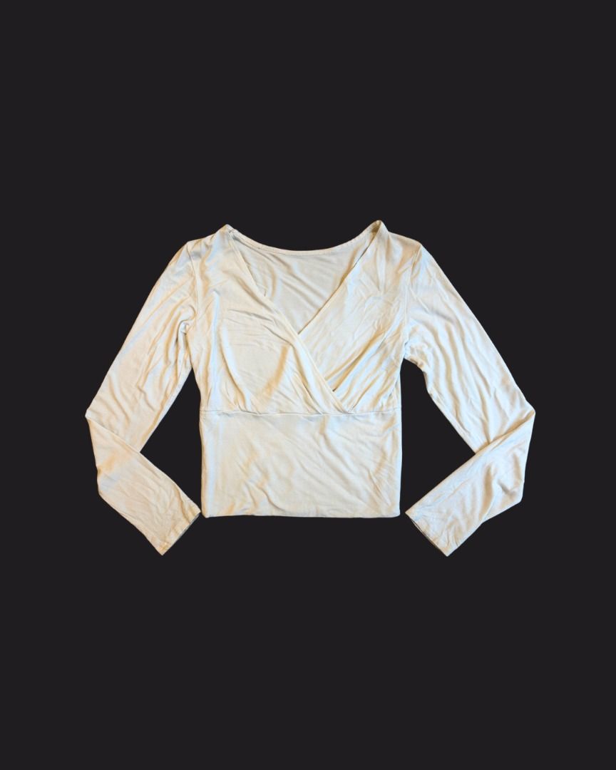 Cream Stretchy Long Sleeve Fitted Wrap Top (Category: Longsleeves) located in Mandaluyong City. Submitted by shopsunnymoody (Listing ID 1457630042, Image 1). Description: Cropped off-white longsleeve stretchy top with deep neckline | Athleisure, ideal for Pilates fits up to Medium length: 40.5 cm width: 31 cm 9/10 quality: needs wash 350 php + SF.