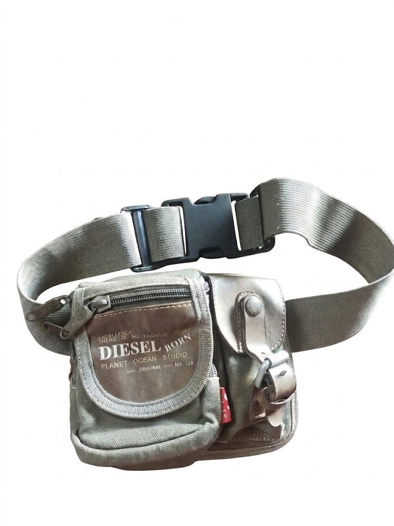 Diesel Born Planet Ocean Studio Waist Bag (Category: Cross-body Bags) located in Valencia. Submitted by coolwolf_27a64f (Listing ID 1456436122, Image 1). Description: - Olive green Diesel waist bag - Multiple zippered compartments for organization - Adjustable strap with buckle closure for a custom fit - Durable canvas material for long-lasting use - Perfect for hands-free carrying of essentials - Shows some signs of wear but remains in good, fun