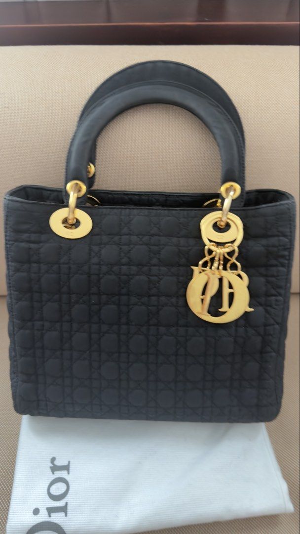 Dior Lady Dior Black Nylon Medium (Category: Luxury Bags & Wallets) located in Caloocan City. Submitted by Sweetie (Listing ID 1457585555, Image 1). Description: - Authentic Dior Lady Dior Bag - Color: Black - Material: Nylon with signature cannage stitching - Hardware: Gold tone - Interior: Red lining with one zip pocket - Features: Top handles, structured base - Includes: Original dust bag.