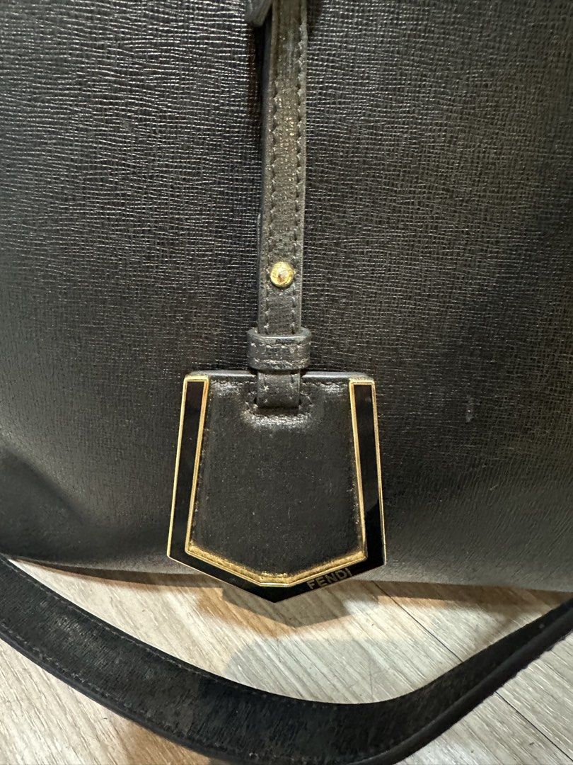 Fendi Black Leather Tote Bag (Category: Luxury Bags & Wallets) located in Baguio. Submitted by thirdy12493 (Listing ID 1457612691, Image 3). Description: - Classic black Fendi tote bag - Made from textured leather - Features top handles and a detachable shoulder strap - Elegant gold hardware details, including Fendi logo - Spacious interior for essentials - Ideal for daily use or travel.