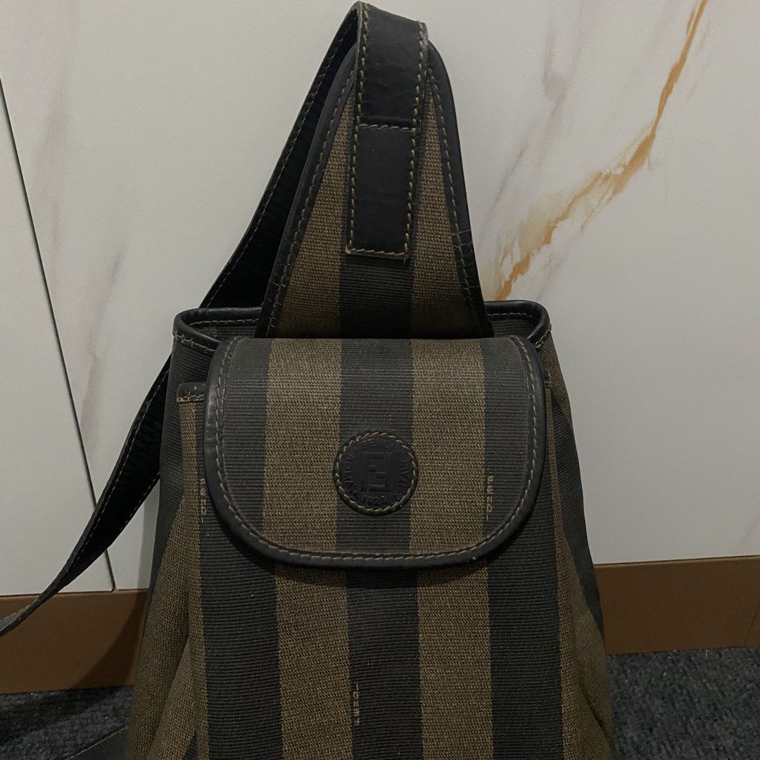 Fendi Peguin Sling Backpack (Category: Luxury Bags & Wallets) located in Baliuag. Submitted by n2s01 (Listing ID 1457585556, Image 3). Description: - Fendi Backpack - From the 2006 Collection - Vintage - Brown - Pequin Pattern - Gold Tone Hardware - Single Adjustable Shoulder Strap - Leather Trim Embellishment - Canvas Lining & Single Interior Pocket - Snap Closure at Front.